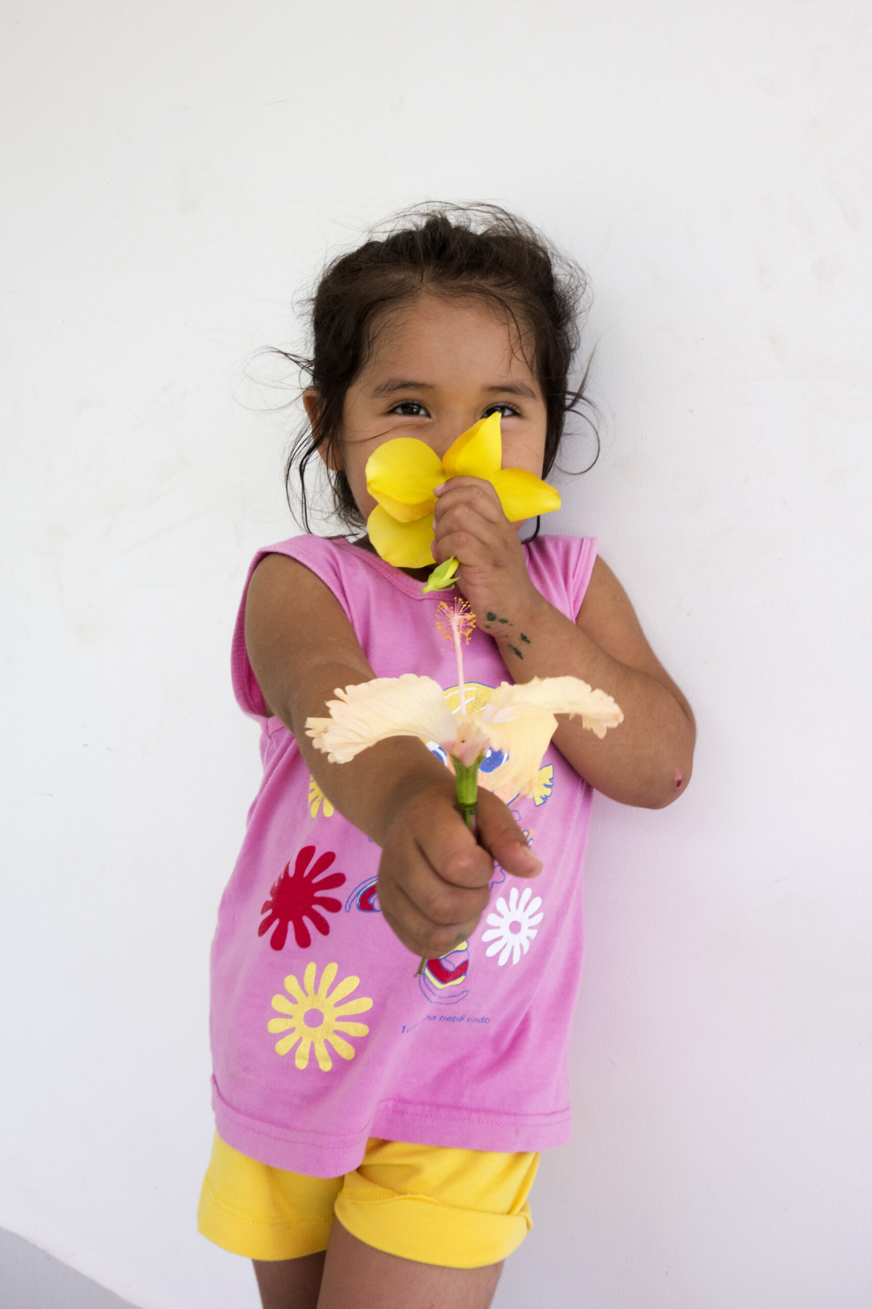 Enfant souriant tenant une fleur